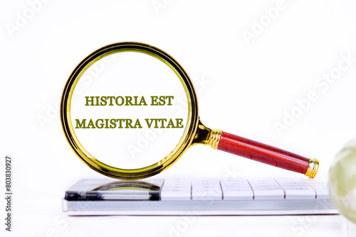 Historia est vitae magistra (History is the tutor of life) Latin phrase inscription was found using a magnifying glass on the calculator. Concept photo photo