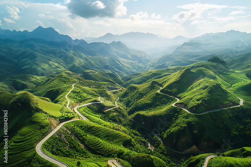 Aerial view of a winding mountain road in Yunnan, China with green mountains and rivers on a sunny day. The photography has a high resolution and was taken with a Canon EOS camera usin photo