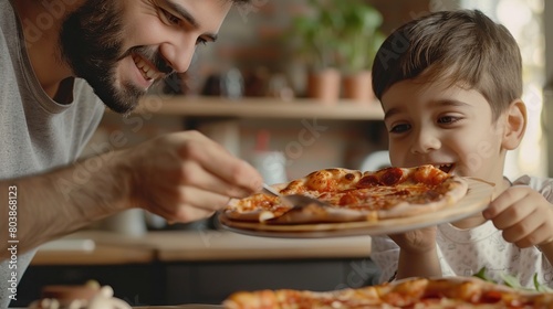 A father and son are eating pizza together. The father is smiling and holding the pizza while the son is taking a bite.
