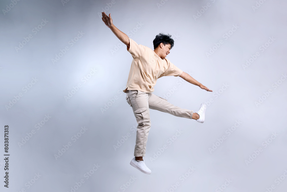 Full Length of Attractive Young Man Jumping and Dancing Isolated on White Background Full Length of Attractive Young Man Jumping and Dancing Isolated on White Background