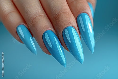Blue manicure close up. Young woman hands with trendy pastel manicure on blue background. Summer fashion manicure.