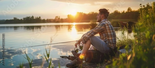 Man fishing on the edge of the lake at sunset photo