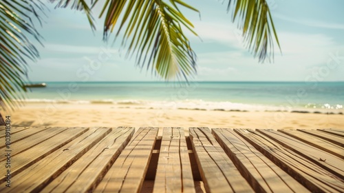 A wooden table facing the sandy beach with a view of the ocean and waves gently crashing