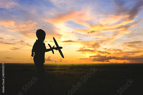 silhouette children play airplan slider at lawn at sunrise © thekopmylife