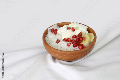 Doi Chira on clay bowl, traditional Bangale healthy and ice cool summer food . Main ingredient is water soaked flatten rice and curd. Others are Sugar, Salt, Banana slices, Pomegranate, Coconut etc.