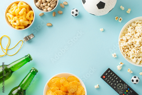 Euro 2024 snack scene: Assorted goodies for soccer fans! From chips to popcorn, crisps to pistachios, ice-cold beer and more. Top view on a pastel blue backdrop, perfect for ads or messages