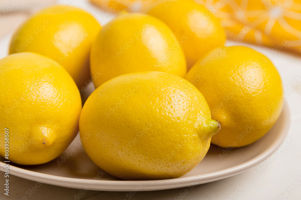 Fresh cutted lemon and whole lemons over round plate on colored background. Food and drink ingredients preparing. healthy eating theme top view vith copy space Fresh cutted lemon and whole lemons over round plate on colored background. Food and drink ingredients preparing. healthy eating theme top view vith copy space