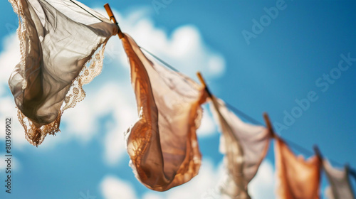 A group of colorful flags hang in the air, resembling laundry drying on a line. The flags create a vibrant and artistic scene