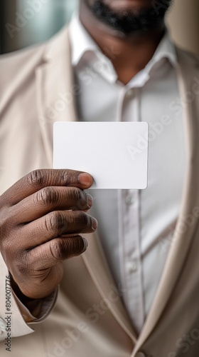 Close-up of a black mans hand in a suit holding a white business card