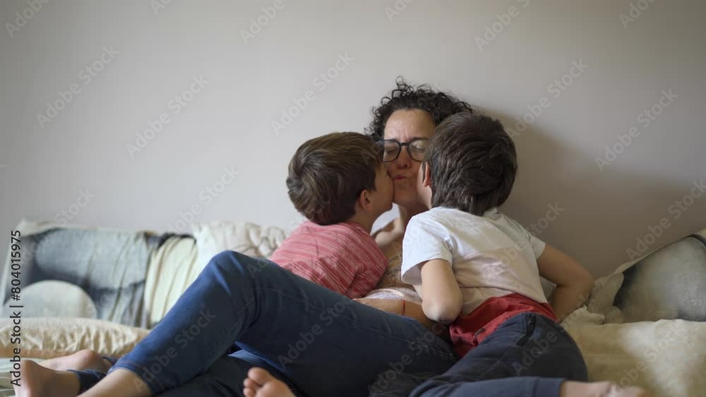 Children kissing mom. Love and affection in the bedroom Children kissing mom. Love and affection in the bedroom