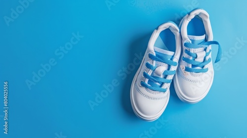 Baby sneakers, child sport shoes pair on blue background. Fashion kids outfit. Fashionable sports shoes. Modern minimalistic layout with footwear mock up for your design. Generative AI