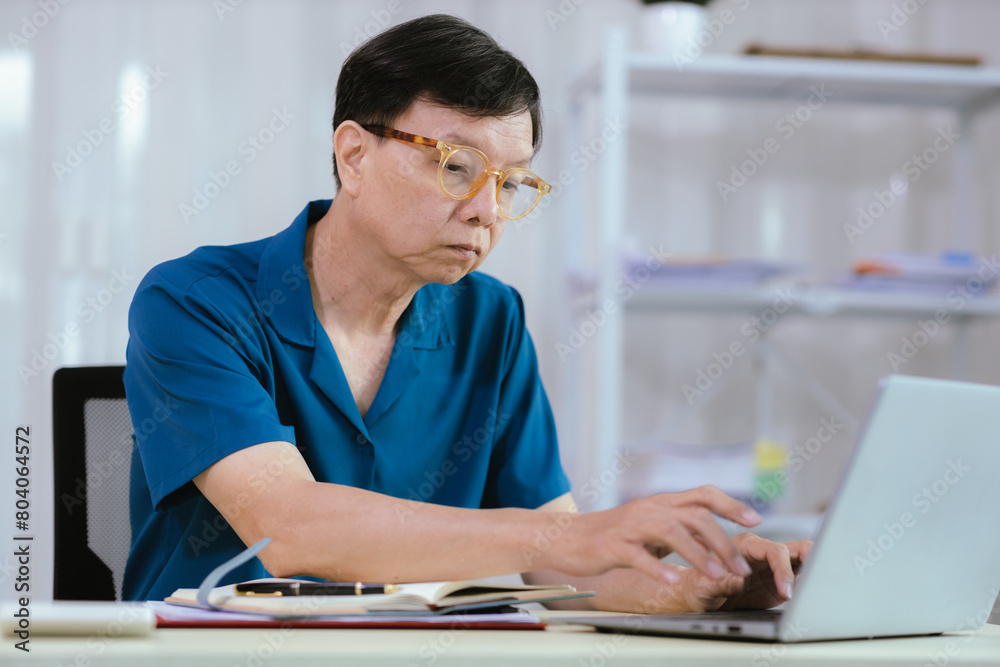 business idea Elderly male businessman working at home or in the office Graph showing annual income Male analyst sitting and working at a table in the office.
