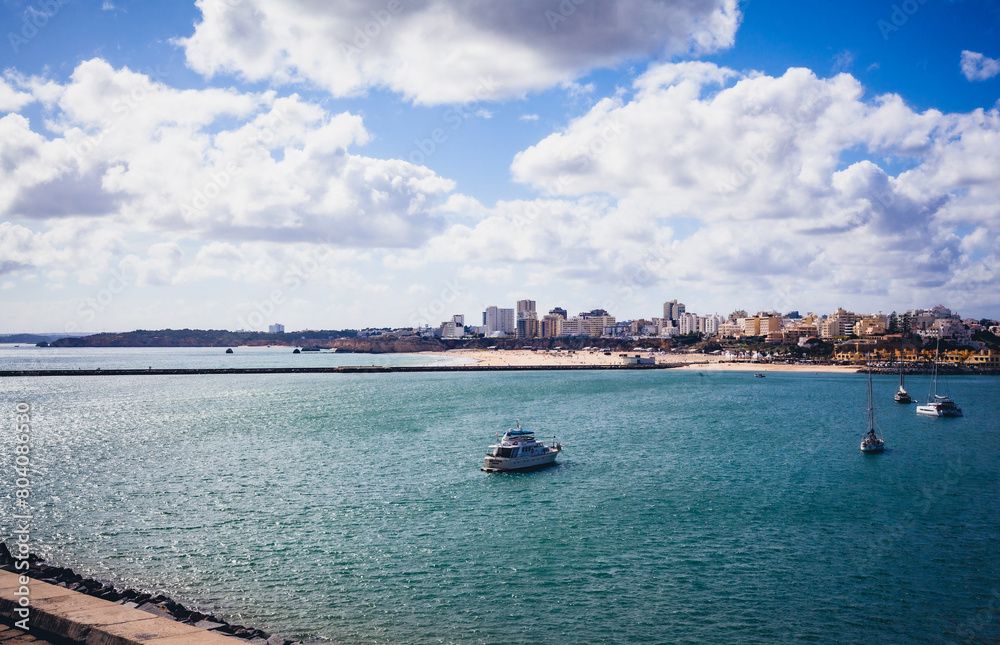 boats in the river arade with portimão city on the horizon boats in the river arade with portimão city on the horizon