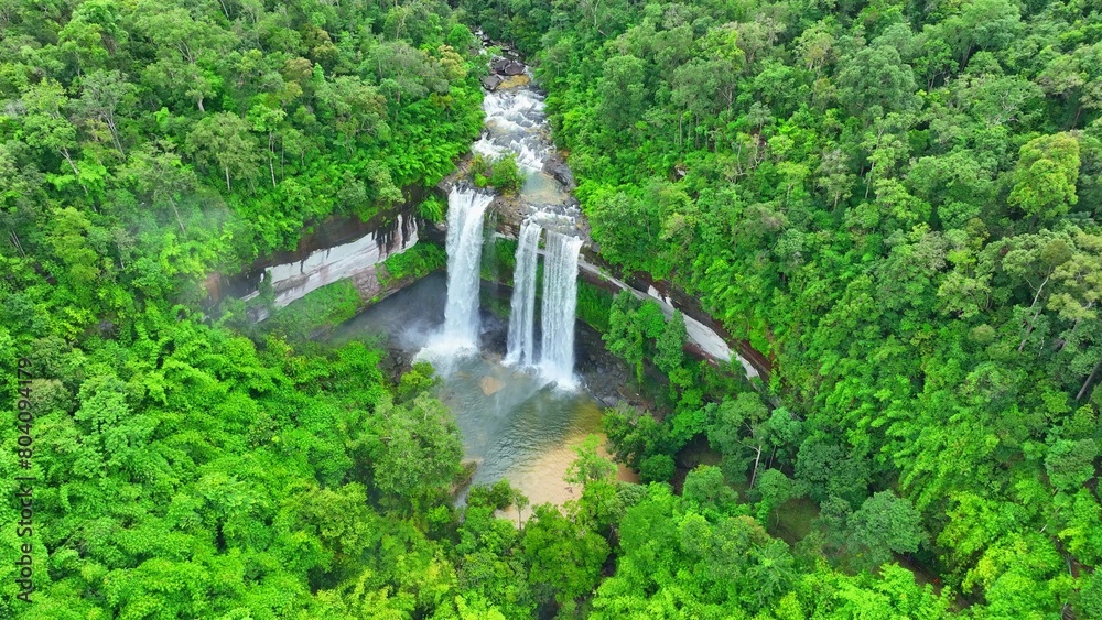 An epic, awe-inspiring waterfall enveloped by a lush, tropical forest, where nature's grandeur takes center stage in a symphony of green and cascading waters. Huai Luang Waterfall, Thailand. Drone.
