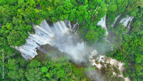 Obraz na plátně Enveloped in lush rainforest, a hidden grand waterfall emerges, its cascading waters glistening in the sunlight