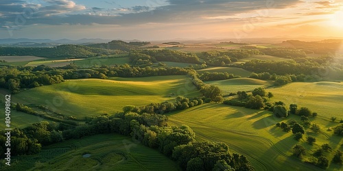 Aerial view of Alcarria lush fields and woodlands bathed in the warm glow of a sunset sky photo