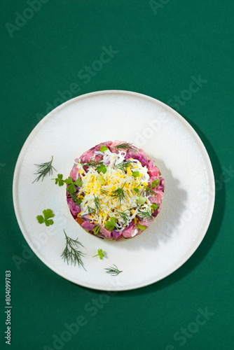 Rosolje -  Estonian beet and herring salad or Rosoli Finland salad with boiled beets, potatoes, apples, onions,  herring or other fish. Ingredients of  Scandinavian cuisine, green background
