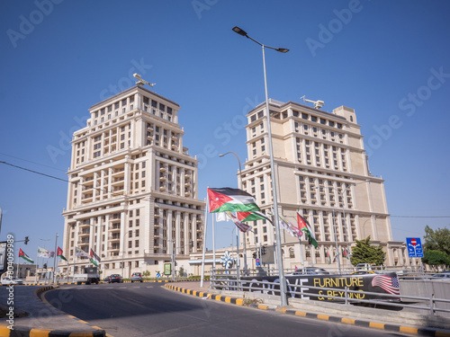 tall modern buildings and jordanian national flag poles at the circle of capital amman