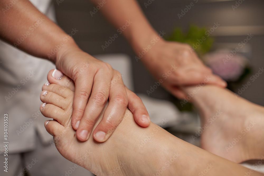 Massage therapist doing foot and leg massage with hands Massage therapist doing foot and leg massage with hands