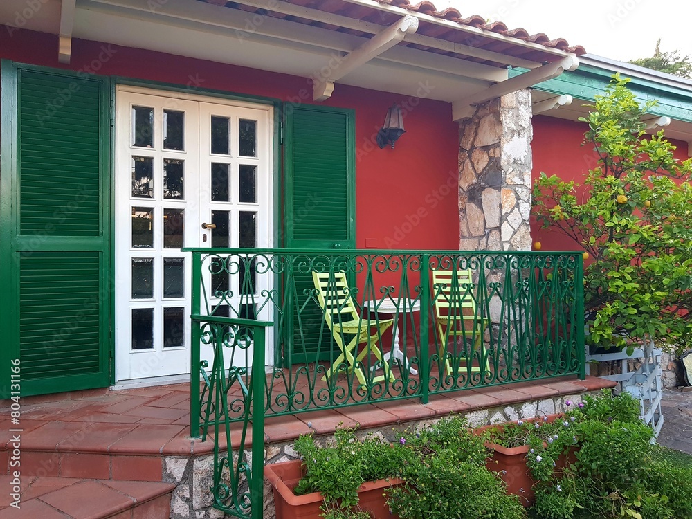 Colorful house with green and red wooden door and green balustrade Stock Photo | Adobe Stock