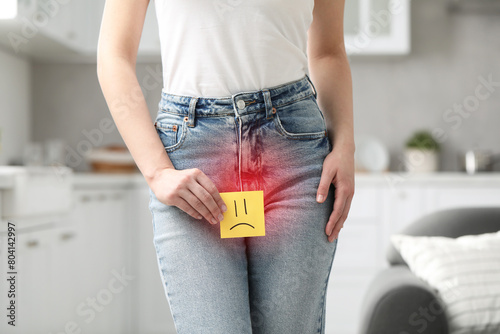Canvastavla Woman holding sticky note with drawn sad face and suffering from cystitis sympto