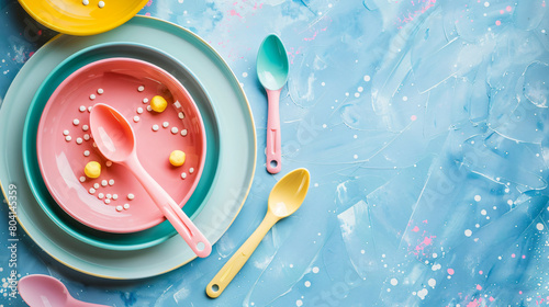 Colorful plates with eating utensils for baby on grung photo
