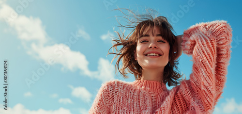 Portrait of a smiling woman standing against a blue sky