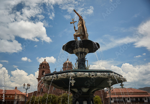 Statue on water fountain with clouds and Peruvian architecture Cusco Peru