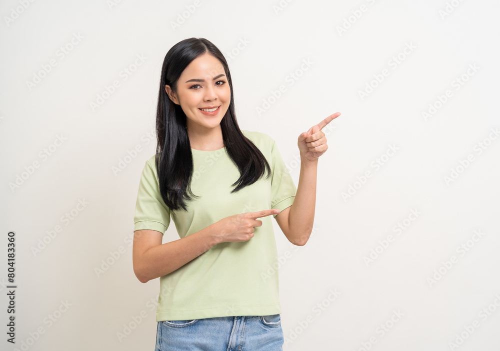 Beautiful smiling happy young asian woman in green shirt. Charming female lady pointing finger to copy space on isolated white background. Asian woman cute Pretty people looking blank space. Beautiful smiling happy young asian woman in green shirt. Charming female lady pointing finger to copy space on isolated white background. Asian woman cute Pretty people looking blank space.