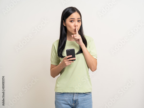 Pretty young asian woman using cellphone standing on isolated white background. Happy Excited Beautiful young asian shopping online payment with mobile phone. Playing game on smartphone