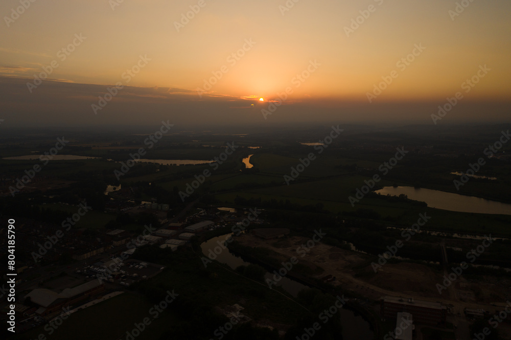 Aerial photo of the beautiful sun setting over the town of Castleford in the district of Wakefield in the UK, showing roof top view of typical British UK rows of houses and streets.