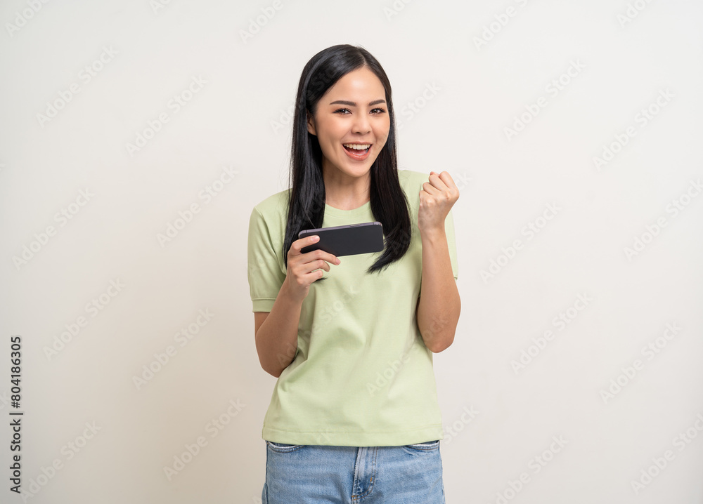 Excited Beautiful young asian women play mobile game and standing on isolated white background. Happy smiling female Playing game on smartphone winning victory moment. Very enjoy and fun relax time Excited Beautiful young asian women play mobile game and standing on isolated white background. Happy smiling female Playing game on smartphone winning victory moment. Very enjoy and fun relax time