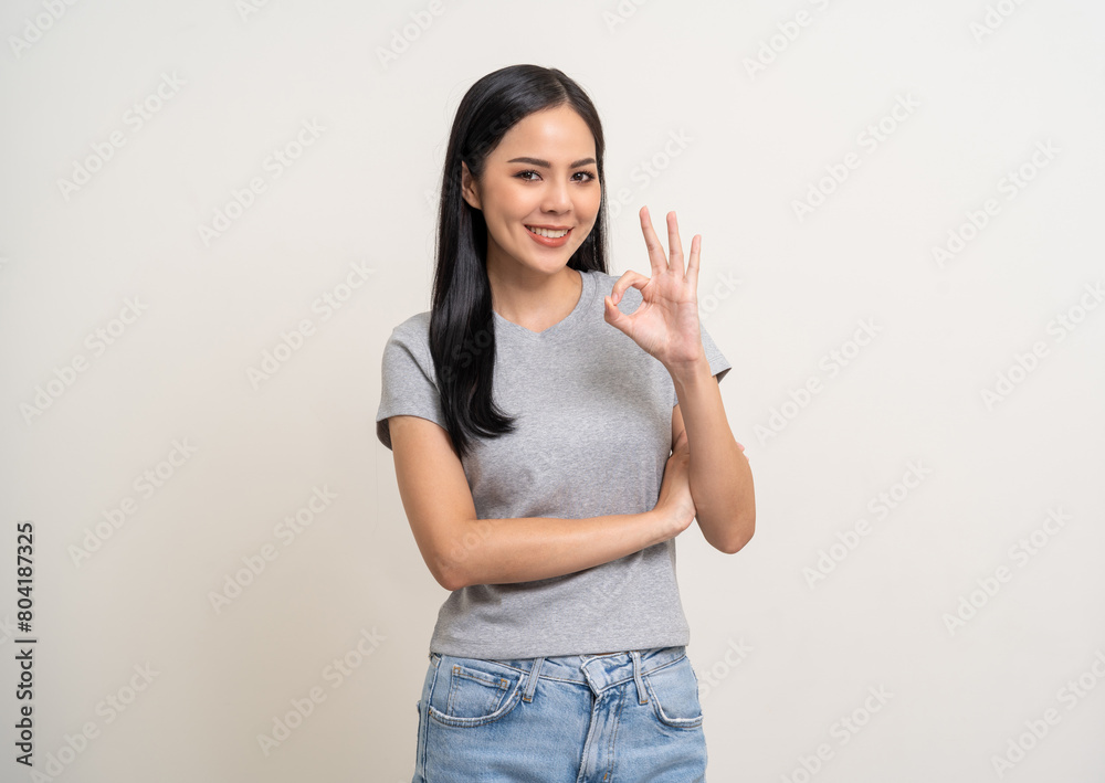 Beautiful smiling happy young asian woman age around 25 in gray shirt. Charming female lady standing pose on isolated white background. Asian woman people looking camera confident with backdrop. Beautiful smiling happy young asian woman age around 25 in gray shirt. Charming female lady standing pose on isolated white background. Asian woman people looking camera confident with backdrop.