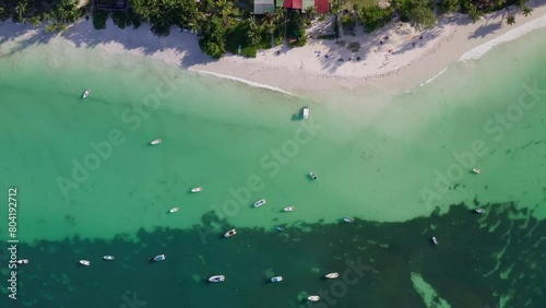 Top down aerial view of the beautiful Anse Volbert beach on Praslin Island. White sandy beach; boats parked near the coast; resorts and houses on the beach; transparent turquoise waters; Seychelles photo