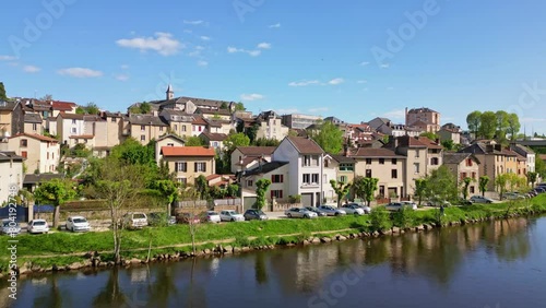 Drone flying over Vienne river with Maison diocésaine or diocesan house in background, Limoges in France. Aerial forward ascending. Sky for copy space photo