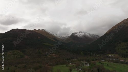 Slow aerial panning shot revealing the snowy beinn a bheithir in Scotland photo