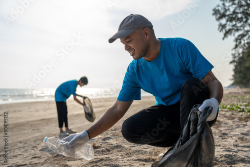 Group teamwork volunteer pick up the plastic bottle on the beach. People male and female Volunteer with garbage bags clean the trash on the beach make the sea beautiful. World environment day CSR.