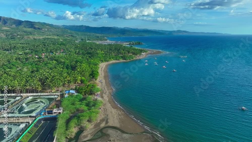 Aerial drone flight over coastline of Sarangani with beach and traditional bangka, fishing boats in south Philippines. Birds eye shot in summer season. photo