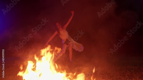 asiatic female young model girl dancing near the fire bonfire flame at night  photo