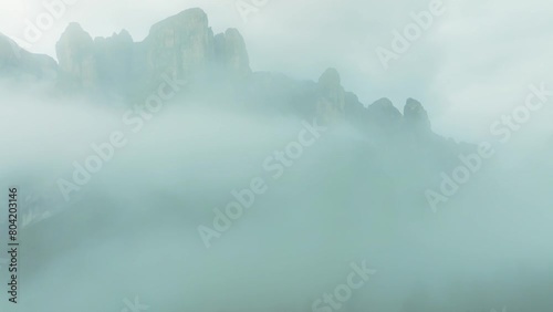 Aerial drone footage. The drone is flying backwards through a mist right after rain in the Dolomites near Val Gardena pass. Val Setus mountain, Italy. LuPa Creative. photo