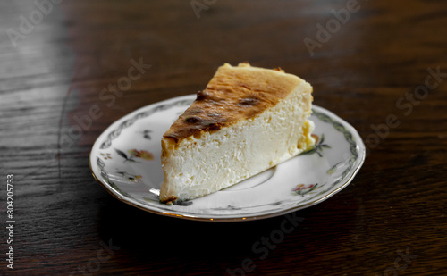 Cheesecake on a plate on a wooden table
