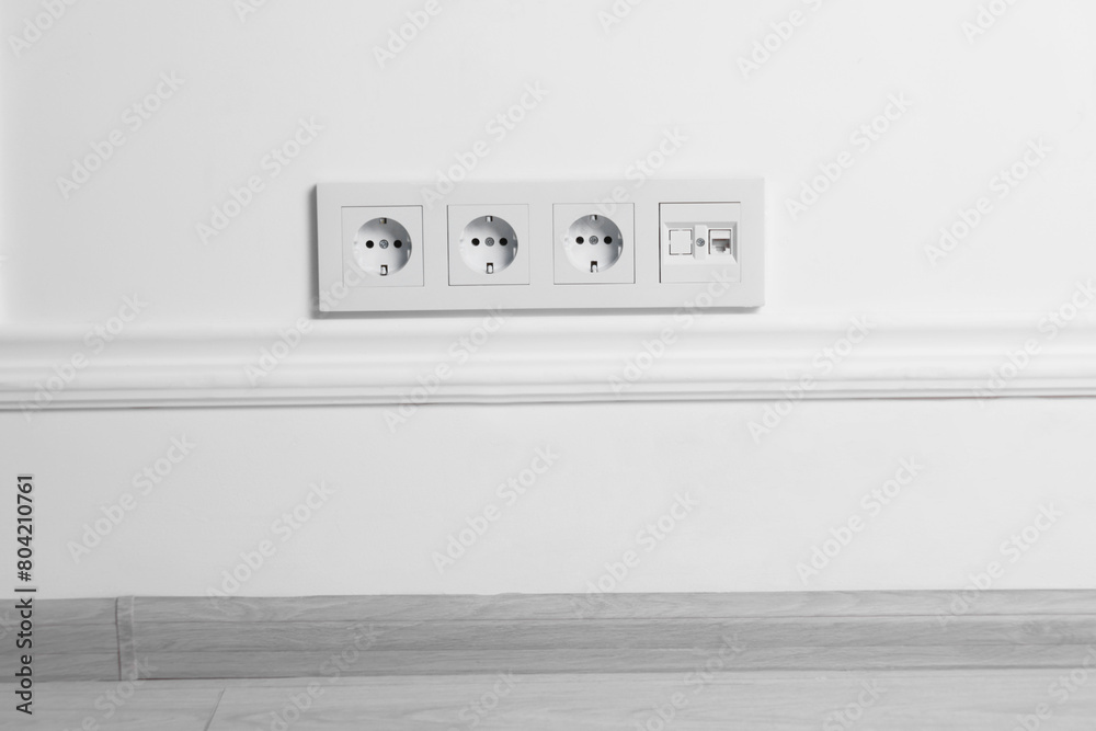 Electric power sockets on white wall indoors Electric power sockets on white wall indoors