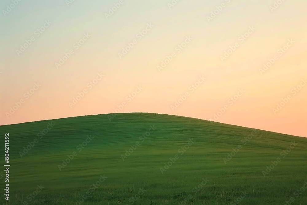 The smooth contour of a hill under a pastel sunset