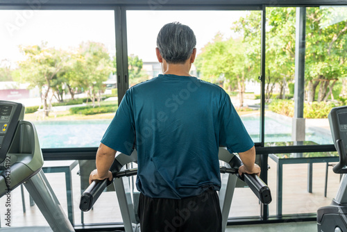 Senior old man runner exercise indoor gym. fitness man jogging wearing sportswear. Mature athlete man in sportswear Workout running on the treadmill.