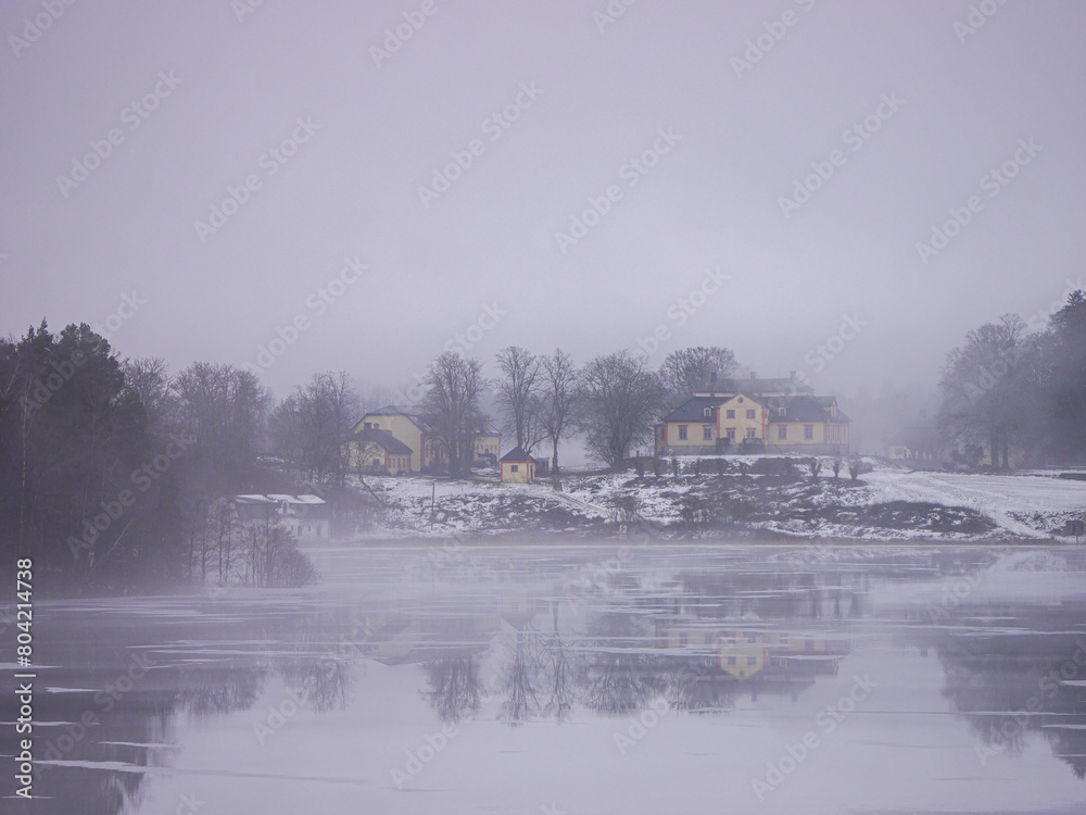 A building by a lake during winter A building by a lake during winter
