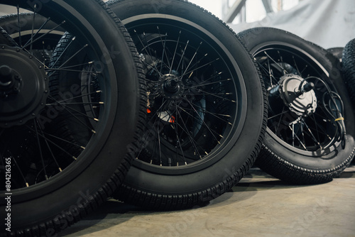 Storage of new motorcycle wheels in the workshop. Front view of rubber tyres with metal spokes