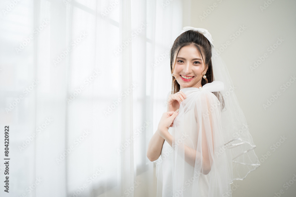 Beautiful asian bride with fashion wedding hairstyle and makeup. Portrait of young gorgeous bride wedding studio shot in white room. Beautiful asian bride with fashion wedding hairstyle and makeup. Portrait of young gorgeous bride wedding studio shot in white room.