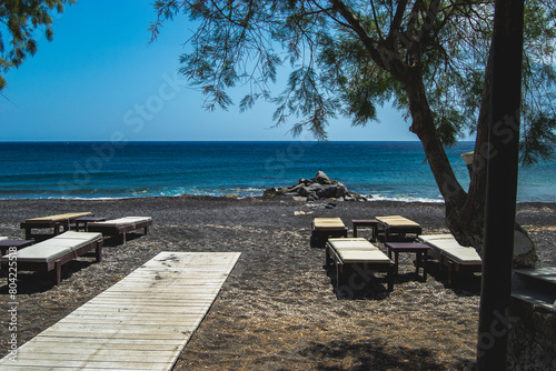 Plage de sable noir et village de Perissa, sur l'ile de Santorin, en Grèce, au mois d'avril 2024.  photo