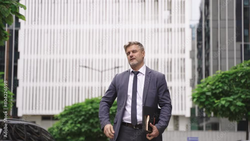 Businessman walking with laptop and notebook in the city. Slow motion Slow motion Businessman walking with laptop and notebook in the city. Slow motion Slow motion