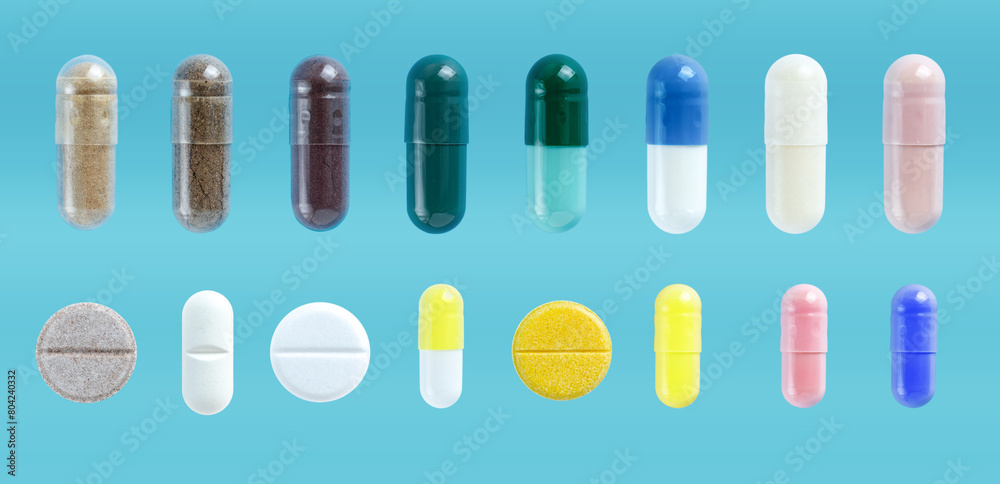 Medical pills and capsules set, on blue background. Pharmaceutical painkiller drugs. Tablets of different colors. Medical pills and capsules set, on blue background. Pharmaceutical painkiller drugs. Tablets of different colors.